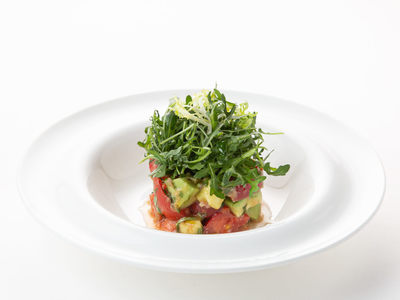 Avocado salad with tomatoes, coriander leaves, and basil
