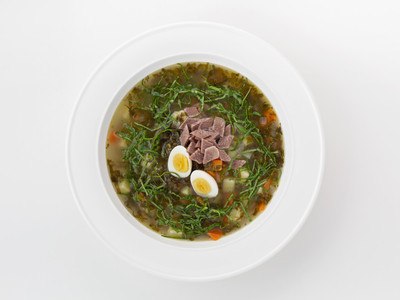 Green vegetable soup with sorrel, quail eggs and sour cream